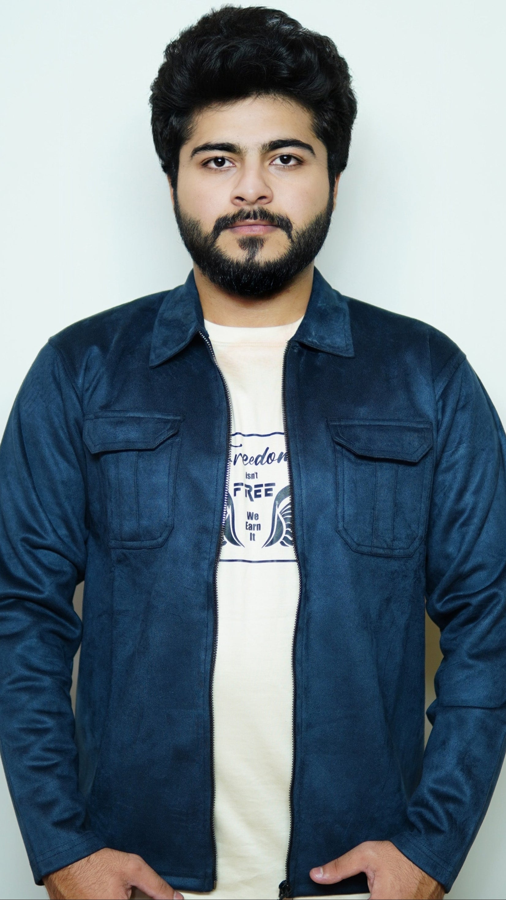 Man wearing a blue denim jacket over a white t-shirt with text on a plain background