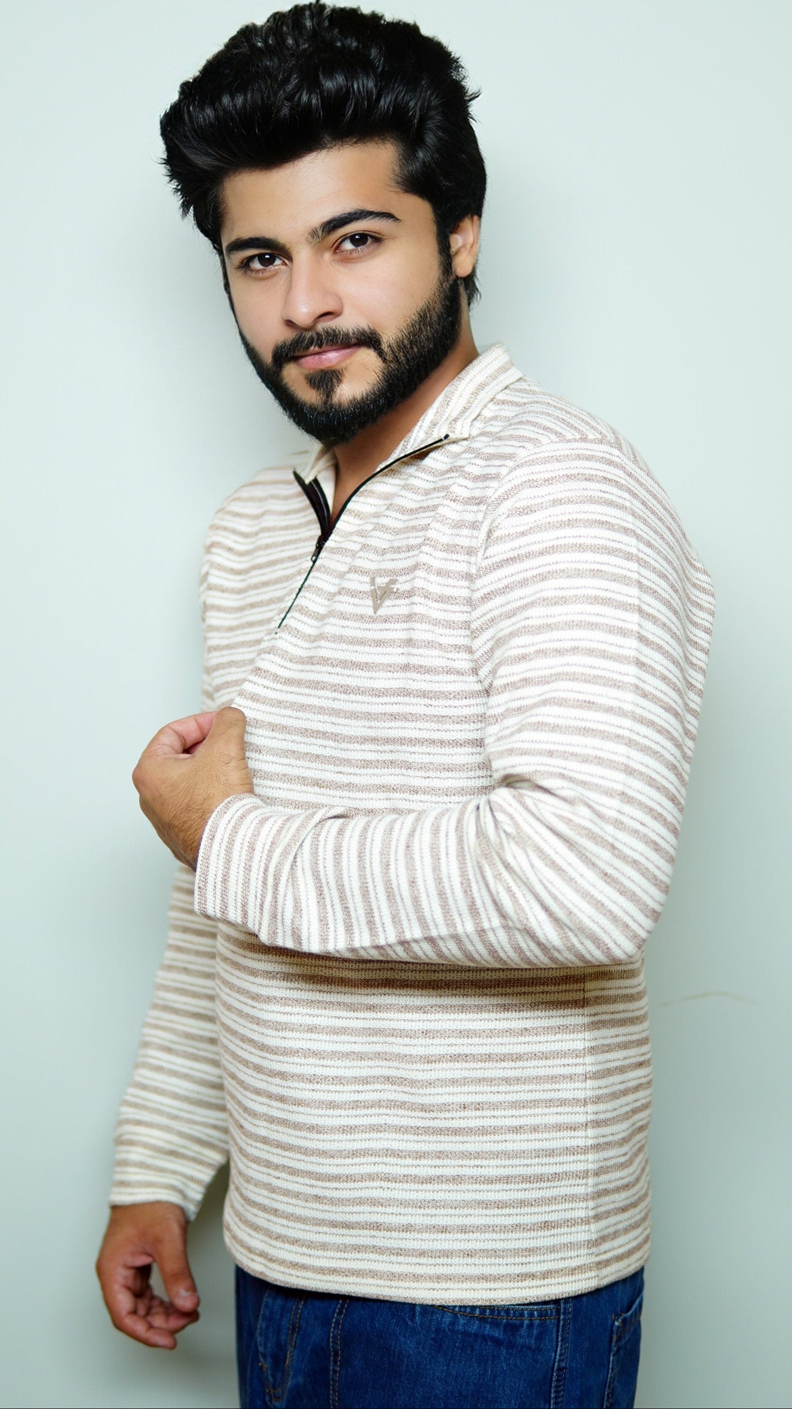 Man wearing a striped sweater against a light blue background