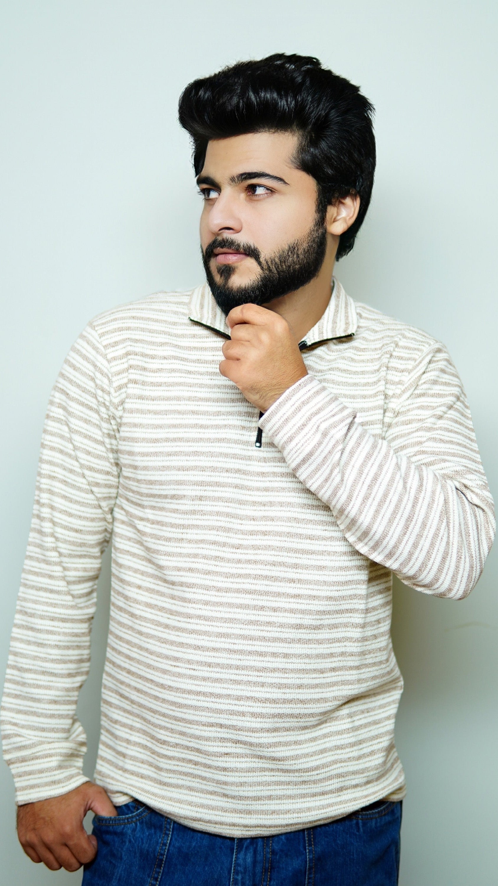 Man wearing a striped sweater against a light background