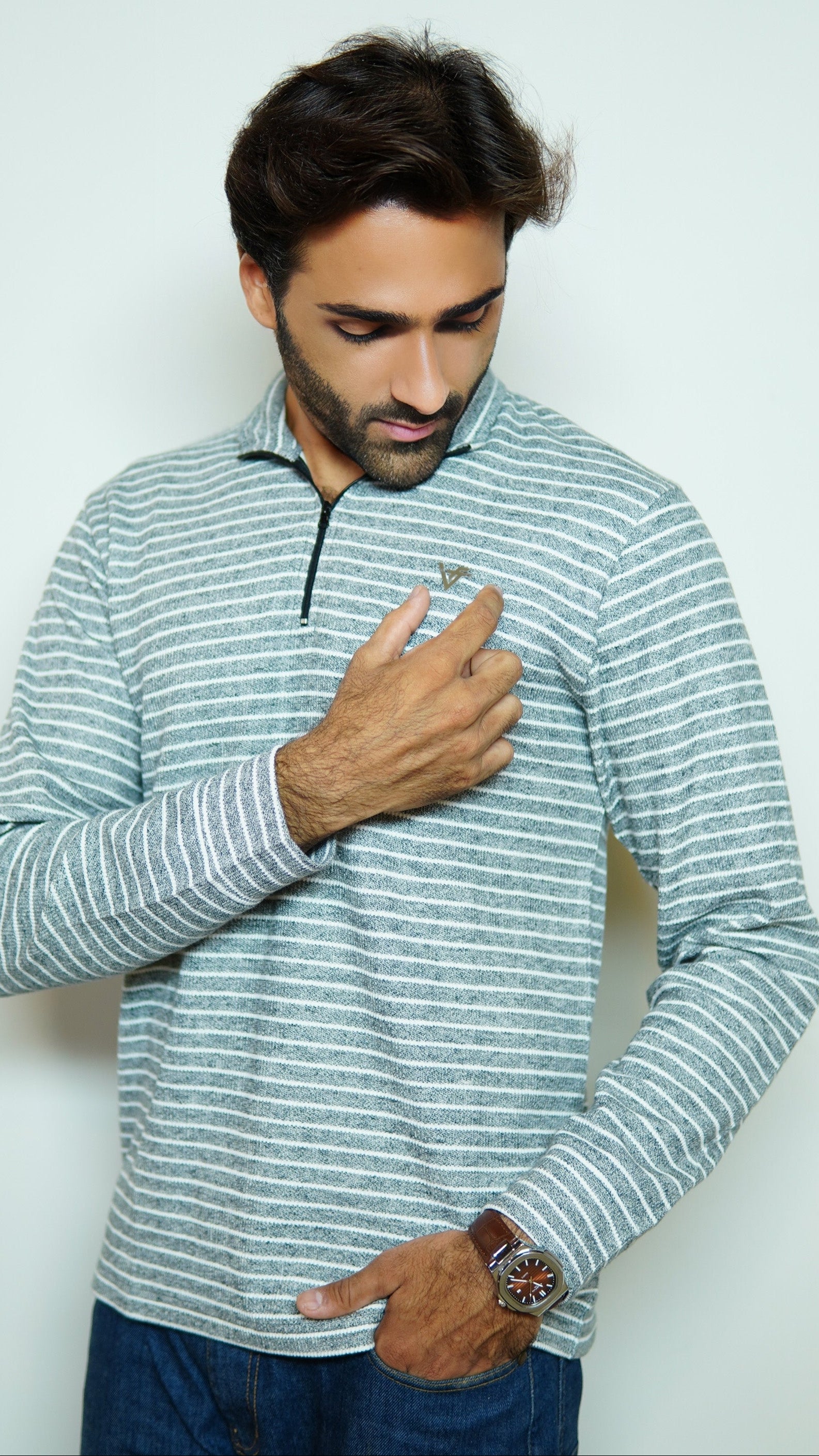 Man wearing a striped long-sleeve shirt against a plain background