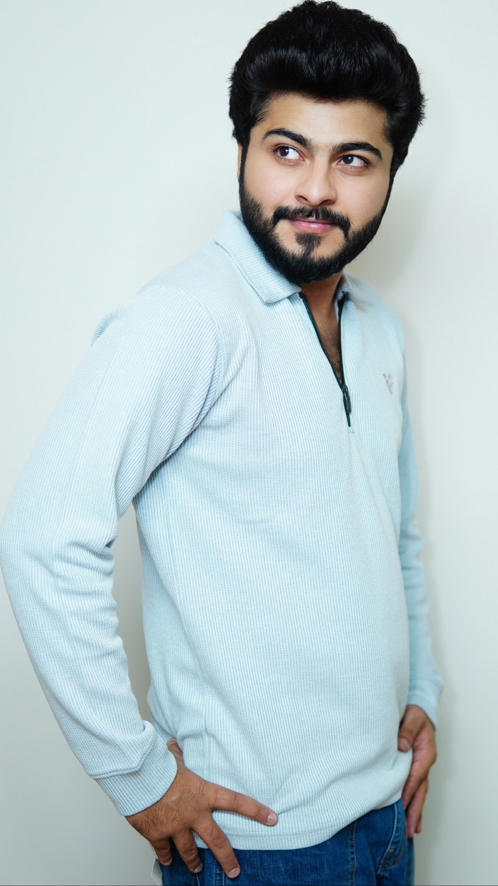 Man wearing a light blue sweater against a white background